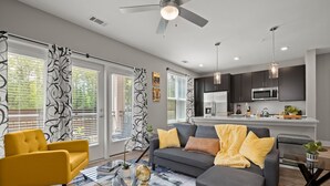 A modern living room with a sofa, armchair, and coffee table. - Studio/Self Check-In/30+Day Stays (Goose Creek)