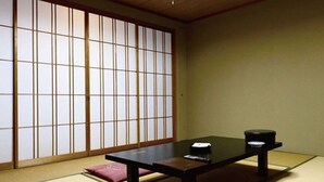A traditional Japanese room with tatami flooring, a low table, and sliding shoji doors. - Inawashiro Kanko Hotel  (Inawashiro)