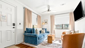 Un salon moderne avec un canapé bleu, une table basse en bois et un fauteuil marron.