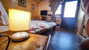 Une pièce en bois avec un lit, une télévision et une lampe.