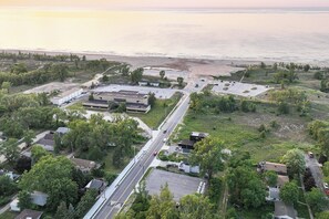An aerial view of a coastal area with a road, parking lot, and buildings. - Spacious 3BR House With Firepit & Grill, Near Beach (Gary)