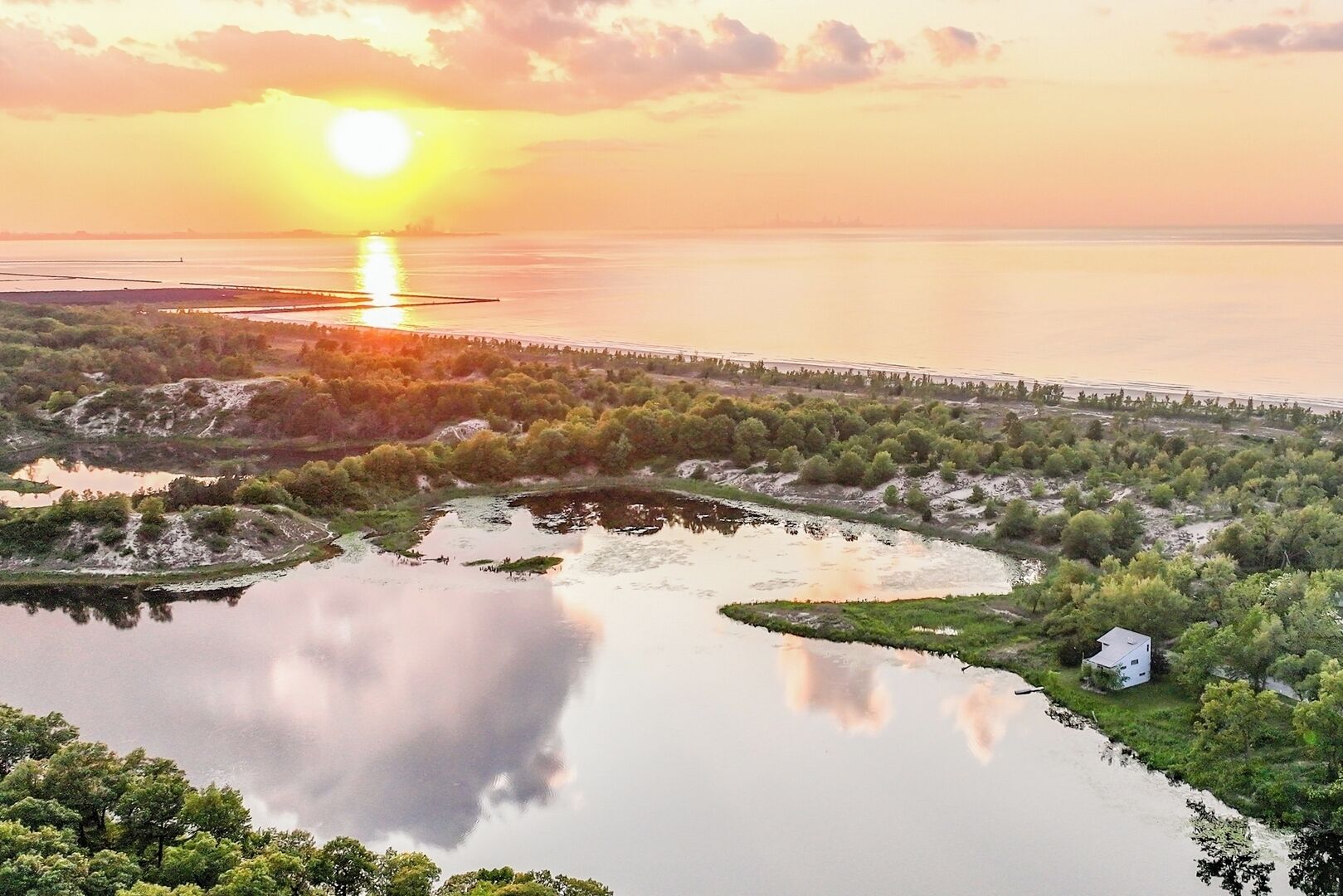 A serene landscape with a body of water, a bridge, and dense greenery.