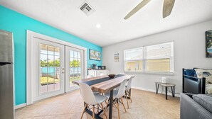 Una cocina moderna con una mesa y sillas de madera, un refrigerador y un comedor con vistas al exterior.
