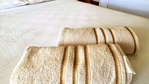 A hotel room with two beds, each with white linens and wooden headboards. There are two nightstands with lamps, and a blue wall above the beds. - Refúgio Praiano do Atalaia (Salinópolis)