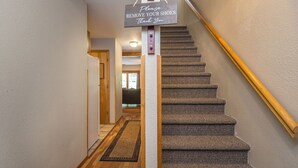 Eine Teppichtreppe mit einem Schild, das zum Schuhe Ausziehen auffordert.