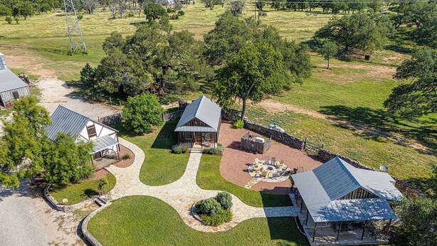 Vista aérea de una zona residencial con varias casas, un sendero de piedra y un área con hogar.