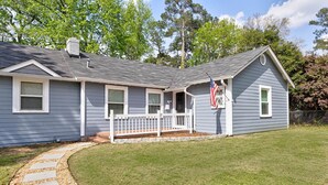 A single-story house with a front porch, a small deck, and a flag. - Pet-Friendly Home by Trail & Base (Columbus)