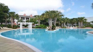 A swimming pool with lounge chairs and palm trees, surrounded by a building with a white gazebo. - Observation Pt N 252-4 at Baytowne Warf- Pool, Gym, and Large Private Balcony! (Miramar Beach)