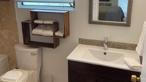 A bathroom with a toilet, sink, and mirror.