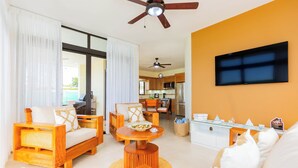 A spacious living area with a sofa, chairs, a dining table, and a TV mounted on the wall. - villa mon Fleur w/jacuzzi,free shuttle at casa linda (Sosua)