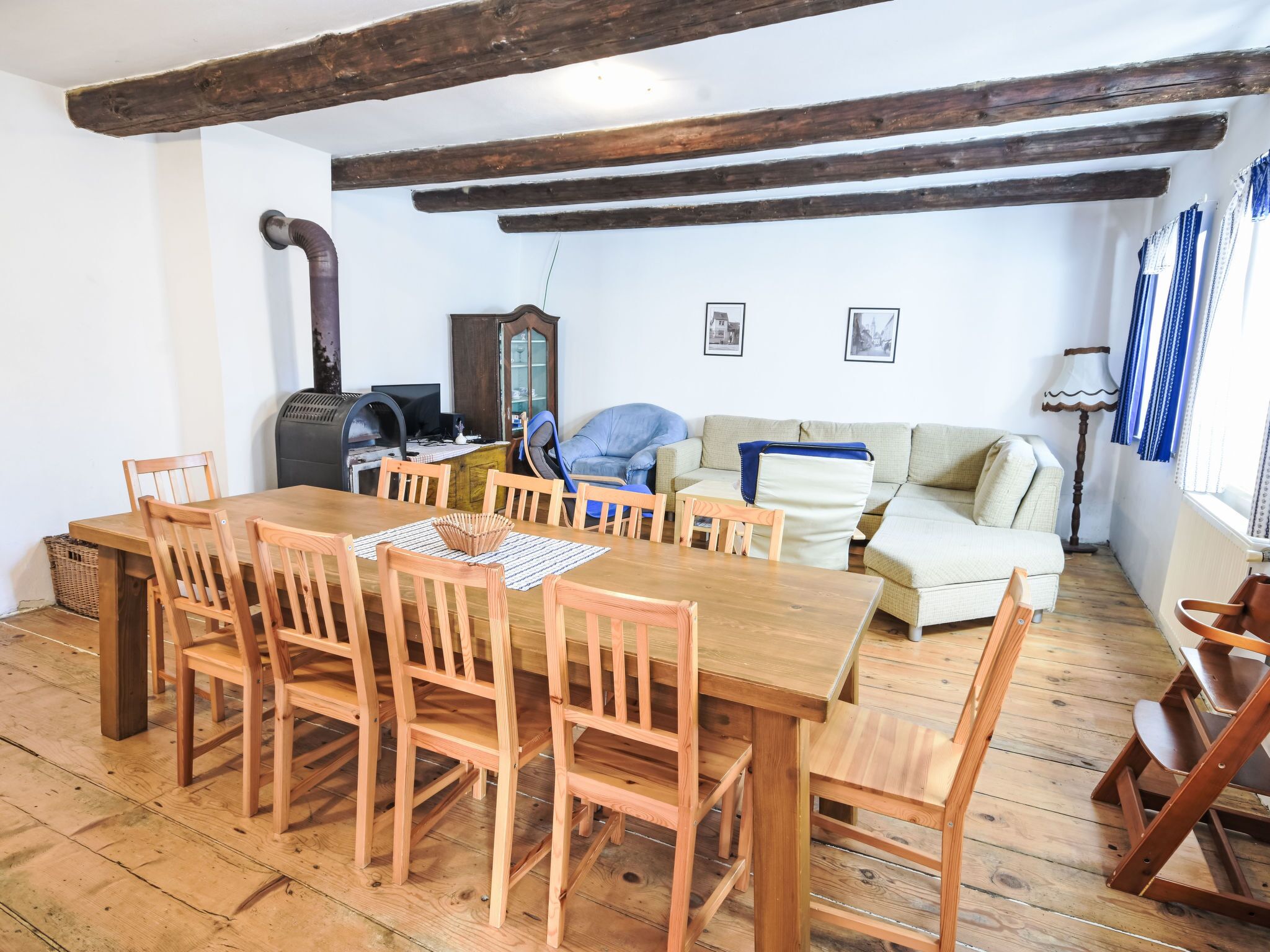 Un'area pranzo con un tavolo e sedie in legno, un divano e un camino.
