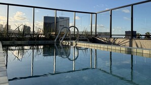 Una piscina infinita en la azotea con vistas despejadas del horizonte urbano.