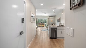 A modern kitchen with white cabinets, a dishwasher, and a view to an outdoor deck. - Condo on property at LaCosta Golf Resort & Spa with Pool 694 (Carlsbad)
