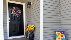 A black door with a wreath, a vase of sunflowers, and a 'Welcome' sign on a house. - New Home • 8 Miles to LBI .BBQ. Family friendly.  (Stafford Township)