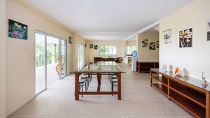 A spacious room with a glass-top dining table, chairs, and a wooden bench. - Villa Jolam - Family Haven in an Island Paradise - Camotes (Poro)