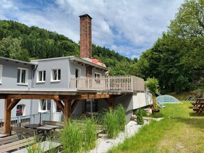 A two-story building with a balcony, wooden deck, and a chimney. - U Dzina by Interhome (Desná v Jizerských horách)