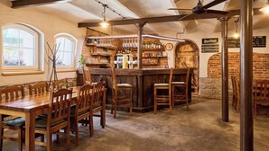 Un espace bar avec des meubles en bois, un mur en briques et un tableau affichant le menu.