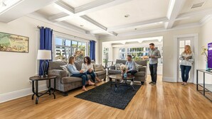 Ein geräumiges Wohnzimmer mit großem Fenster, Kamin und Couchtisch.