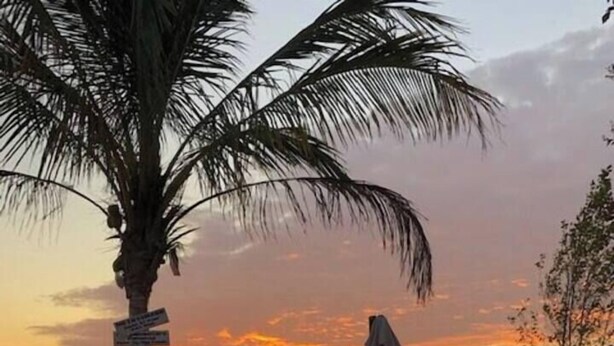Ein Lagerfeuer am Strand mit Blick auf den Sonnenuntergang.