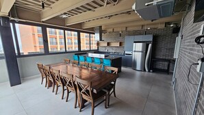 A spacious kitchen with a large dining table and chairs, a brick wall, and a view of buildings outside. - New apartment with beautiful views in Lomas del Country (Guadalajara)