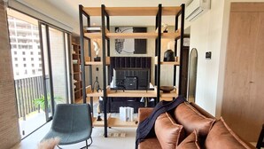 A modern living room with a sofa, a chair, and a built-in shelving unit with a fireplace. - New apartment with beautiful views in Lomas del Country (Guadalajara)