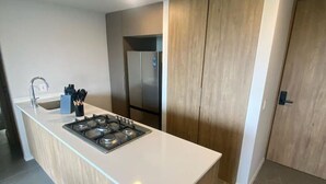 Une cuisine moderne dotée d’un îlot central, d’appareils électroménagers en acier inoxydable et d’un meuble en bois.