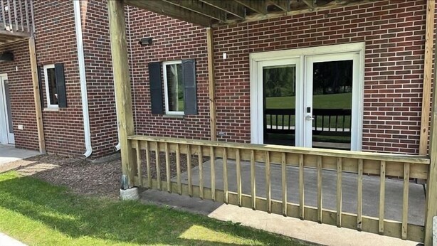A brick building with a wooden deck and a white door. - Apartment Centrally Located (Plymouth)