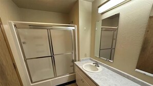 Een badkamer met een inloopdouche, een wastafel en een spiegel.