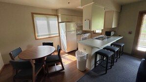A compact kitchen with a dining area, a refrigerator, a stove, and a sink. - Apartment Centrally Located (Plymouth)