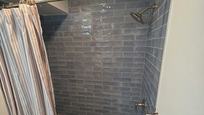 Ein Badezimmer mit Dusche, Toilette und Badewanne.
