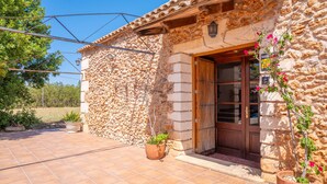 A stone building with a wooden door and potted plants. - SON FIGUEROLA - Beautiful villa with private pool and free Wi-Fi in Inca (Inca)