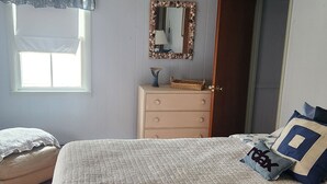 A bedroom with a bed, dresser, mirror, and window. - Upper floor of charming 2 story house in central Hawley with WiFi (Hawley)