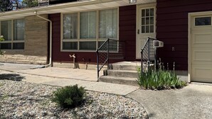 A two-story house with a stone chimney, large windows, and a front porch. - 3 Bedroom Merrillville Escape, quiet, rural w/ shopping centers, spacious (Merrillville)