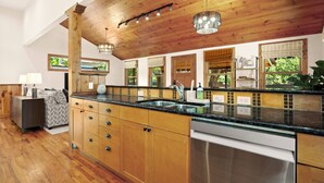 Een moderne keuken met houten kastjes, een roestvrijstalen vaatwasser en een groot eiland met een spoelbak.