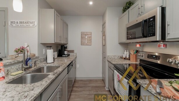 Cocina moderna con encimeras de granito, electrodomésticos de acero inoxidable y un cartel que indica que el desayuno está incluido.