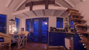 Una cocina con un armario azul, una silla de madera y una mesa de comedor.