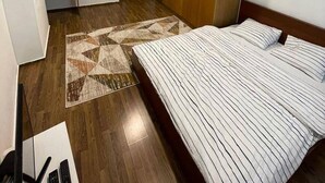 Une chambre d’hôtel avec un lit, un plancher en bois et un tapis à motifs.