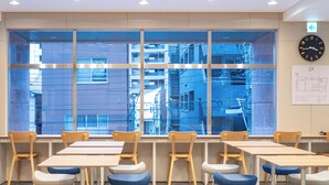 A classroom with tables and chairs, large windows with a view of buildings, a clock, and a map on the wall. - Toyoko Inn Tokyo Minowa eki (Tokyo)