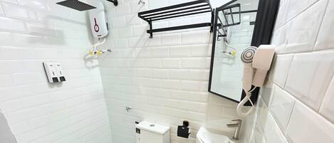 Un baño moderno con azulejos blancos, inodoro, lavabo, espejo, toallero y ducha.