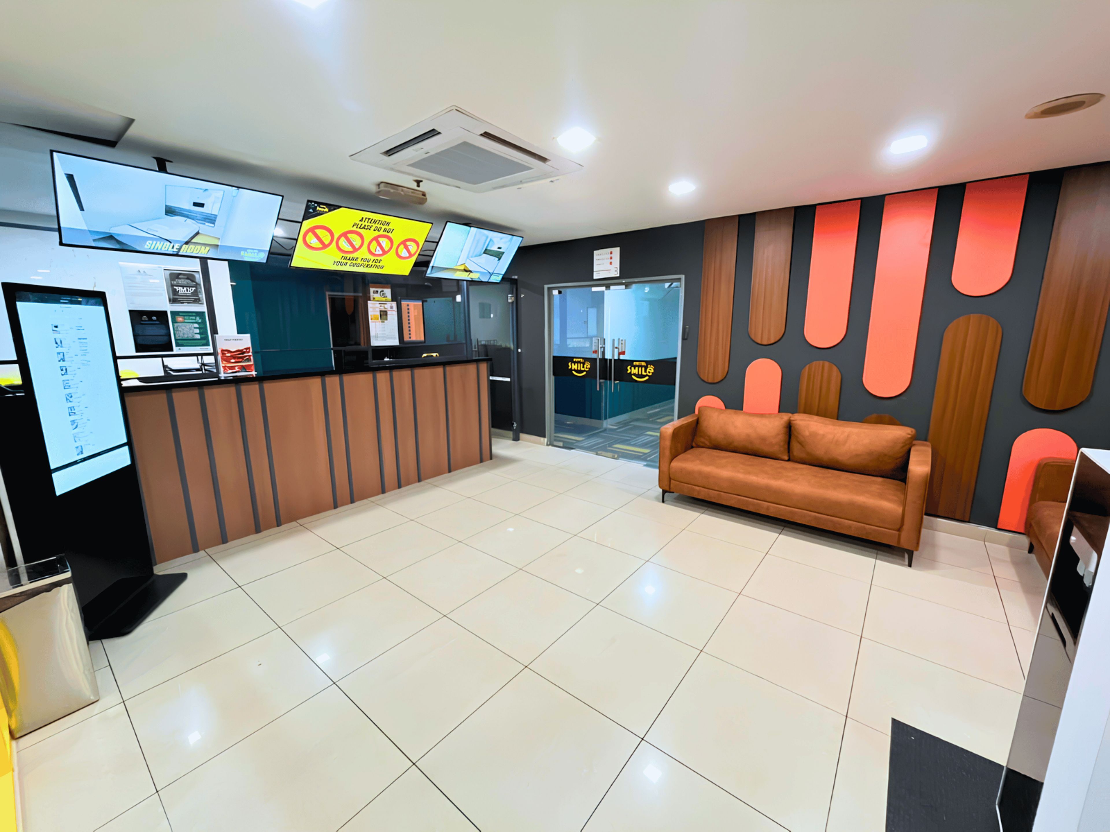 A reception area with a reception desk, a brown sofa, and a wall with abstract patterns.