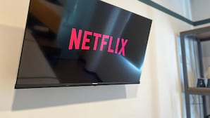 Un televisor de pantalla plana montado en la pared, mostrando el logo de Netflix.