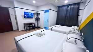 Habitación de hotel con dos camas, un escritorio, una silla, un televisor y un armario.
