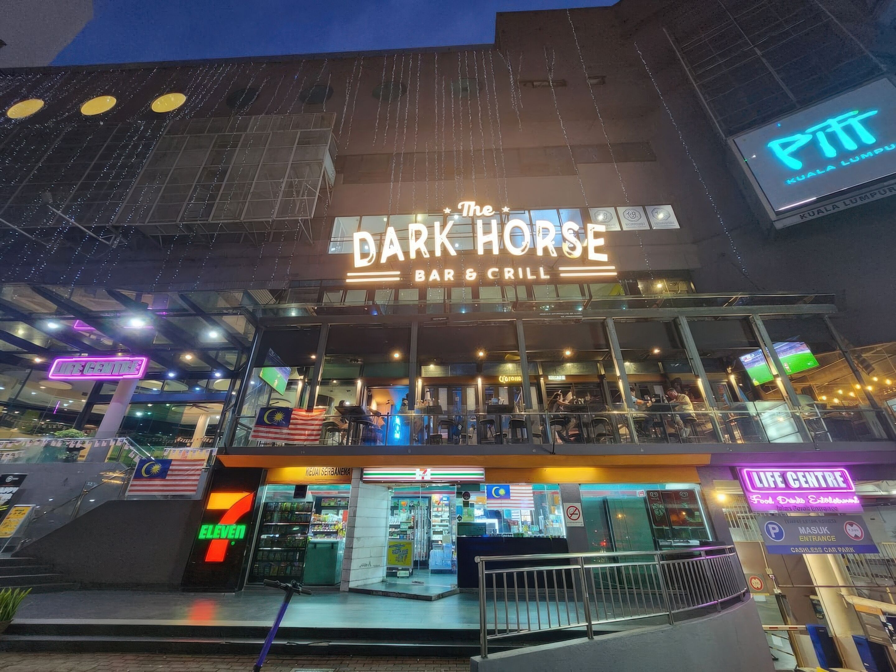 The Dark Horse Bar & Grill with a 7-Eleven store and a Life Centre sign.
