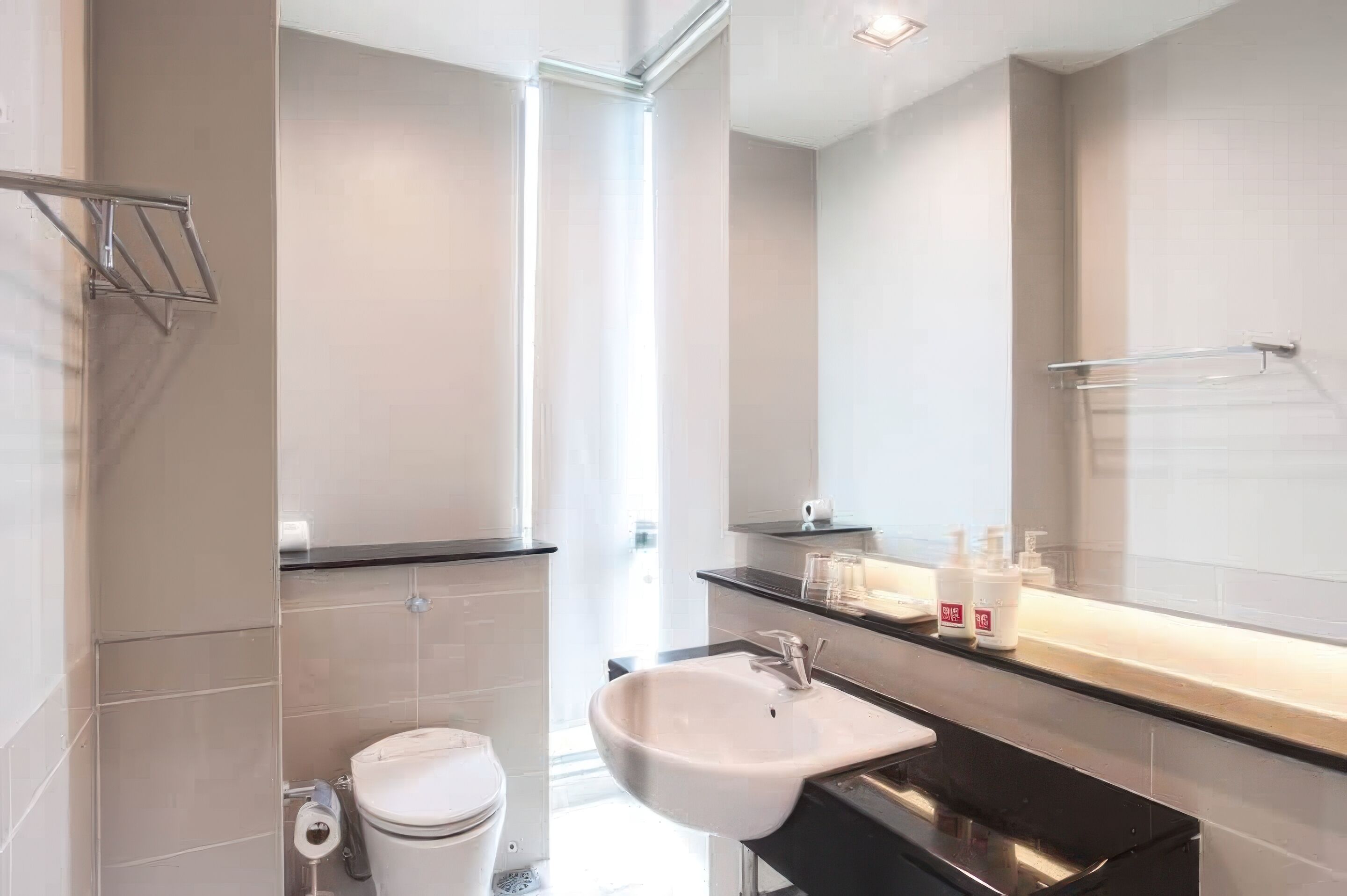 A modern bathroom with a toilet, sink, and towel rack.