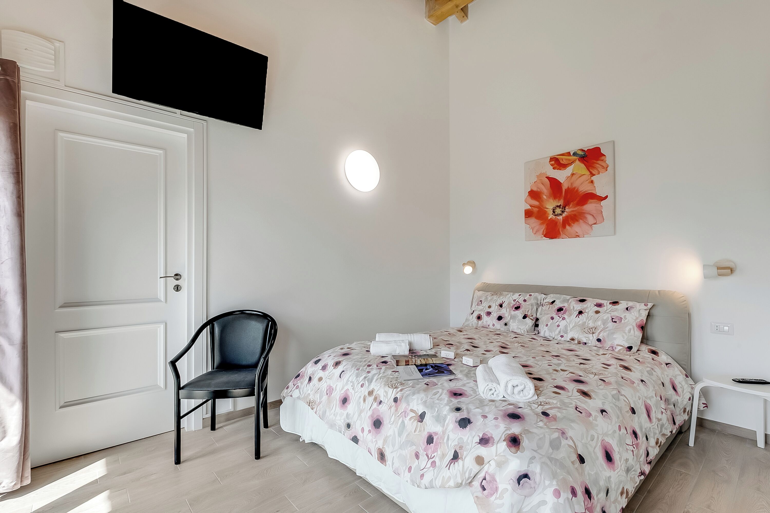 A neatly arranged bedroom with a bed, a chair, and a door.