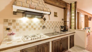 A kitchen with a gas stove, a sink, and wooden cabinets. - Dimora Lucretili by Interhome (Tivoli)