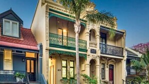 A two-story building with a balcony, a staircase, and a number '43' on the door. - Balmain Village Retreat | Sleeps 5 | AC + Parking | City 3kms (Balmain)