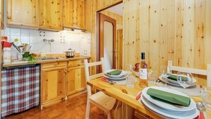 Une cuisine en bois avec un coin repas aménagé pour deux personnes.
