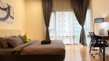A modern bedroom with a large bed, a desk, and a chair.