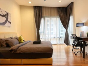 Un dormitorio moderno con una cama grande, un escritorio y una silla.